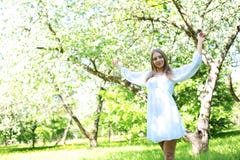 Gelukkige blondevrouw op een achtergrond van bloeiende de lentetuin met haar die handen aan de hemel wordt opgeheven royalty-vrije stock foto Gelukkige blondevrouw op een achtergrond van bloeiende de lentetuin met haar die handen aan de hemel wordt opgeheven royalty-vrije stock foto
