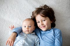 Gelukkige broers, baby en peuterkinderen, die thuis koesteren stock foto's Gelukkige broers, baby en peuterkinderen, die thuis koesteren stock foto's