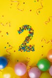 Gelukkige die Verjaardag nummer 2 van suikergoed met kleurrijke ballons op gele achtergrond wordt gemaakt stock fotografie Gelukkige die Verjaardag nummer 2 van suikergoed met kleurrijke ballons op gele achtergrond wordt gemaakt stock fotografie