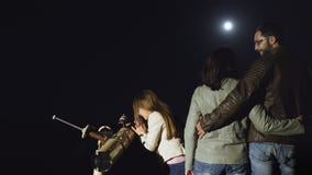 Gelukkige familie die op de maan in een telescoop letten bij nacht stock footage Gelukkige familie die op de maan in een telescoop letten bij nacht stock footage