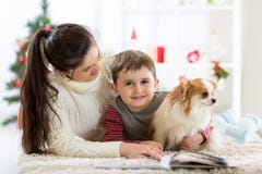 Gelukkige familie en de hond die samen Kerstmistijd doorbrengen thuis dichtbij de Kerstboom Het concept van het nieuwjaar Royalty-vrije Stock Fotografie