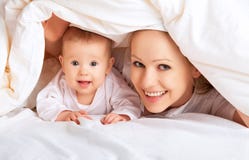 Gelukkige familie. Moeder en baby het spelen onder deken Gelukkige familie. Moeder en baby het spelen onder deken