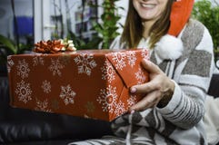 Gelukkige glimlachende jonge mooie vrouw die en een Kerstmisgift houden geven royalty-vrije stock foto's Gelukkige glimlachende jonge mooie vrouw die en een Kerstmisgift houden geven royalty-vrije stock foto's
