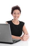 Gelukkige jonge bedrijfsvrouwenzitting bij bureau met laptop royalty-vrije stock afbeelding Gelukkige jonge bedrijfsvrouwenzitting bij bureau met laptop royalty-vrije stock afbeelding
