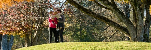 Gelukkige jonge familie met twee jonge geitjes in een park royalty-vrije stock foto's Gelukkige jonge familie met twee jonge geitjes in een park royalty-vrije stock foto's