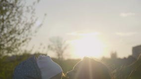 Gelukkige Kaukasische moeder en peuterdochter in openlucht in park op zonnige de lentedag Jonge donkerbruine moeder die haar ophe stock video Gelukkige Kaukasische moeder en peuterdochter in openlucht in park op zonnige de lentedag Jonge donkerbruine moeder die haar ophe stock video