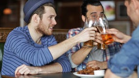 Gelukkige mannelijke vrienden die bier drinken bij bar of bar Gelukkige mannelijke vrienden die bier drinken bij bar of bar
