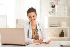 Gelukkige medische artsenvrouw die in bureau werken royalty-vrije stock afbeelding Gelukkige medische artsenvrouw die in bureau werken royalty-vrije stock afbeelding