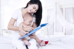Gelukkige moeder en baby die een boek lezen stock fotografie Gelukkige moeder en baby die een boek lezen stock fotografie