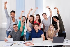 Gelukkige studenten die succes in klaslokaal vieren stock foto Gelukkige studenten die succes in klaslokaal vieren stock foto