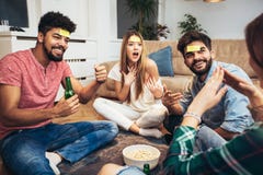 Gelukkige vrienden die spelgissing spelen stock foto Gelukkige vrienden die spelgissing spelen stock foto