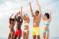 Gelukkige vrienden met handen omhoog op de zomerstrand stock foto Gelukkige vrienden met handen omhoog op de zomerstrand stock foto