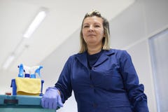 Gelukkige vrouwelijke reinigingsmachine die in bureau glimlacht royalty-vrije stock foto Gelukkige vrouwelijke reinigingsmachine die in bureau glimlacht royalty-vrije stock foto