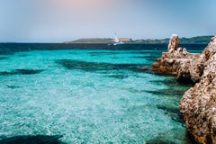 Gemütliche Bucht des schönen Türkises umgeben durch weiße Klippen Weiße Yacht fern im tiefen blauen Wasser Ionische Inseln von stockbild Gemütliche Bucht des schönen Türkises umgeben durch weiße Klippen Weiße Yacht fern im tiefen blauen Wasser Ionische Inseln von stockbild