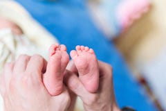 Gene realizar nos pés das mãos do bebê recém-nascido imagem de stock Gene realizar nos pés das mãos do bebê recém-nascido imagem de stock