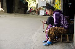 Generi il bambino etnico di parenting di Hmong e cellulare del gioco alla casa immagini stock Generi il bambino etnico di parenting di Hmong e cellulare del gioco alla casa immagini stock