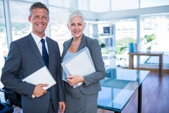 Gens d'affaires heureux regardant l'appareil-photo et tenant le bouclier Images stock Gens d'affaires heureux regardant l'appareil-photo et tenant le bouclier Images stock