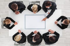 Gens d'affaires s'asseyant autour de la table vide image stock Gens d'affaires s'asseyant autour de la table vide image stock