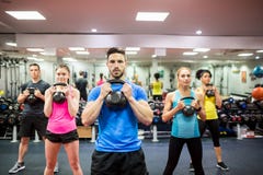 Gente adatta che risolve nella classe di forma fisica immagine stock libera da diritti Gente adatta che risolve nella classe di forma fisica immagine stock libera da diritti