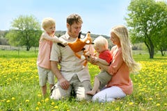 Gente felice di famiglia di quattro che gioca con i giocattoli fuori in fiore immagini stock Gente felice di famiglia di quattro che gioca con i giocattoli fuori in fiore immagini stock