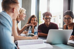 Gente joven que hace estudio del grupo en biblioteca Gente joven que hace estudio del grupo en biblioteca