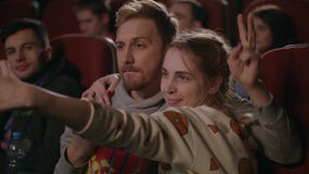 Gente joven que se divierte en el cine Pares del amor que hacen la foto del selfie en cine metrajes Gente joven que se divierte en el cine Pares del amor que hacen la foto del selfie en cine metrajes
