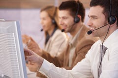 Gente joven que trabaja en la sonrisa del callcenter imagenes de archivo Gente joven que trabaja en la sonrisa del callcenter imagenes de archivo