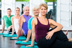 Gente mayor y joven que hace abdominales en gimnasio de la aptitud foto de archivo Gente mayor y joven que hace abdominales en gimnasio de la aptitud foto de archivo