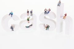Gente miniatura che si siede sulle lettere di legno dei contanti fotografia stock libera da diritti Gente miniatura che si siede sulle lettere di legno dei contanti fotografia stock libera da diritti