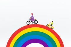 Gente miniatura: Mamma e bambini che ciclano sull'arcobaleno Uso di immagine per essere buon modello, concetto 'nucleo familiare' immagini stock libere da diritti Gente miniatura: Mamma e bambini che ciclano sull'arcobaleno Uso di immagine per essere buon modello, concetto 'nucleo familiare' immagini stock libere da diritti