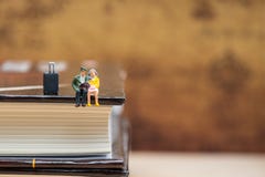 Gente miniatura que se sienta en la esquina del libro fotografía de archivo Gente miniatura que se sienta en la esquina del libro fotografía de archivo