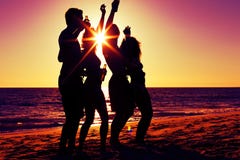 Gente que tiene partido en la playa con las bebidas imagen de archivo libre de regalías Gente que tiene partido en la playa con las bebidas imagen de archivo libre de regalías