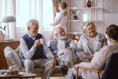 Gente sorridente che parla insieme nella casa di cura fotografia stock Gente sorridente che parla insieme nella casa di cura fotografia stock