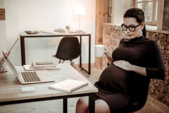 Gentille femme enceinte futée frottant son ventre images libres de droits Gentille femme enceinte futée frottant son ventre images libres de droits