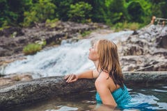 Geothermal Spa. Woman Relaxing In Hot Spring Pool Against The Background Of A Waterfall Stock Image Geothermal Spa. Woman Relaxing In Hot Spring Pool Against The Background Of A Waterfall Stock Image