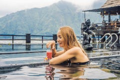 Geothermal Spa. Woman Relaxing In Hot Spring Pool Against The Lake. Hot Springs Concept. Drinking Guava Juice Royalty Free Stock Images Geothermal Spa. Woman Relaxing In Hot Spring Pool Against The Lake. Hot Springs Concept. Drinking Guava Juice Royalty Free Stock Images