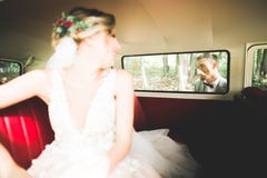 Gerade verheiratetes Paar im Retro- Luxusauto an ihrem Hochzeitstag lizenzfreie stockfotos Gerade verheiratetes Paar im Retro- Luxusauto an ihrem Hochzeitstag lizenzfreie stockfotos