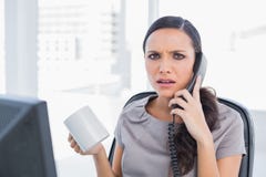 Gereiztes antwortendes Telefon Sekretärs lizenzfreies stockbild Gereiztes antwortendes Telefon Sekretärs lizenzfreies stockbild