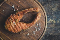 Geroosterde zalm op scherpe raad stock afbeelding Geroosterde zalm op scherpe raad stock afbeelding