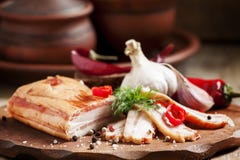 Geräucherter Speck, Knoblauch, roter Pfeffer und Salz auf einem hölzernen Schnittbo Stockbilder Geräucherter Speck, Knoblauch, roter Pfeffer und Salz auf einem hölzernen Schnittbo Stockbilder