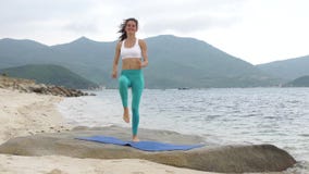 Geschiktheids glimlachende vrouw die sportieve oefening op strand doen buiten bij zonsondergang stock footage Geschiktheids glimlachende vrouw die sportieve oefening op strand doen buiten bij zonsondergang stock footage