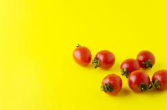 Geschmackvolle frische Kirschtomaten mit Wassertropfen auf gelber heller Tabelle lizenzfreie stockfotos Geschmackvolle frische Kirschtomaten mit Wassertropfen auf gelber heller Tabelle lizenzfreie stockfotos