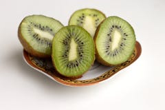Geschnittene Kiwis liegen auf einer Untertasse stockbild Geschnittene Kiwis liegen auf einer Untertasse stockbild
