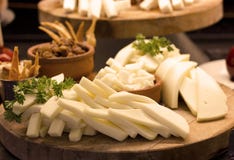 Geschnittener Weißkäse mit Grüns auf einem hölzernen Brett Selektives foc stockfotografie Geschnittener Weißkäse mit Grüns auf einem hölzernen Brett Selektives foc stockfotografie