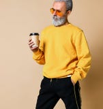 Geschoten van een blije oudste die een witte koffiekop houden en weg camera kijken stock fotografie Geschoten van een blije oudste die een witte koffiekop houden en weg camera kijken stock fotografie