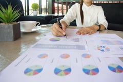Geschäftsfrau, die bei der Arbeit zeigt auf das Diagramm sitzt stockfotografie Geschäftsfrau, die bei der Arbeit zeigt auf das Diagramm sitzt stockfotografie