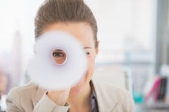 Geschäftsfrau, die durch gerolltes-oben Dokument schaut Stockbild Geschäftsfrau, die durch gerolltes-oben Dokument schaut Stockbild