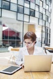 Geschäftsfrau, die mit Laptop und ipad arbeitet lizenzfreie stockbilder Geschäftsfrau, die mit Laptop und ipad arbeitet lizenzfreie stockbilder