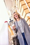 Geschäftsfrau mit Kaffee lächelnd auf der Straße Lizenzfreies Stockbild Geschäftsfrau mit Kaffee lächelnd auf der Straße Lizenzfreies Stockbild