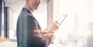 Geschäftsmann, der im modernen Dachboden und in Touch Screen der Tablette steht Unscharfer Stadthintergrund Weit optische Effekte stockfotos Geschäftsmann, der im modernen Dachboden und in Touch Screen der Tablette steht Unscharfer Stadthintergrund Weit optische Effekte stockfotos